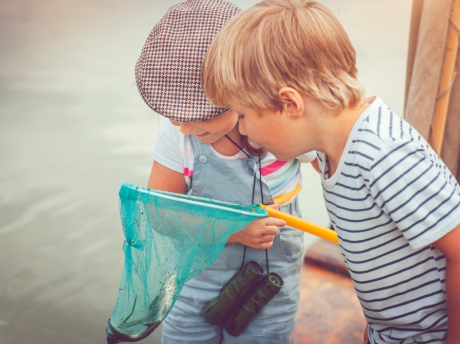 To børn kigger på dyr i et fiskenet