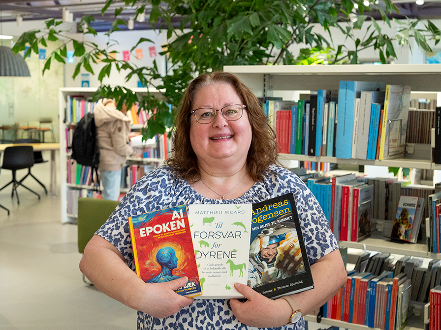 Billede af bibliotekar Ulla, som holder tre bøger. 